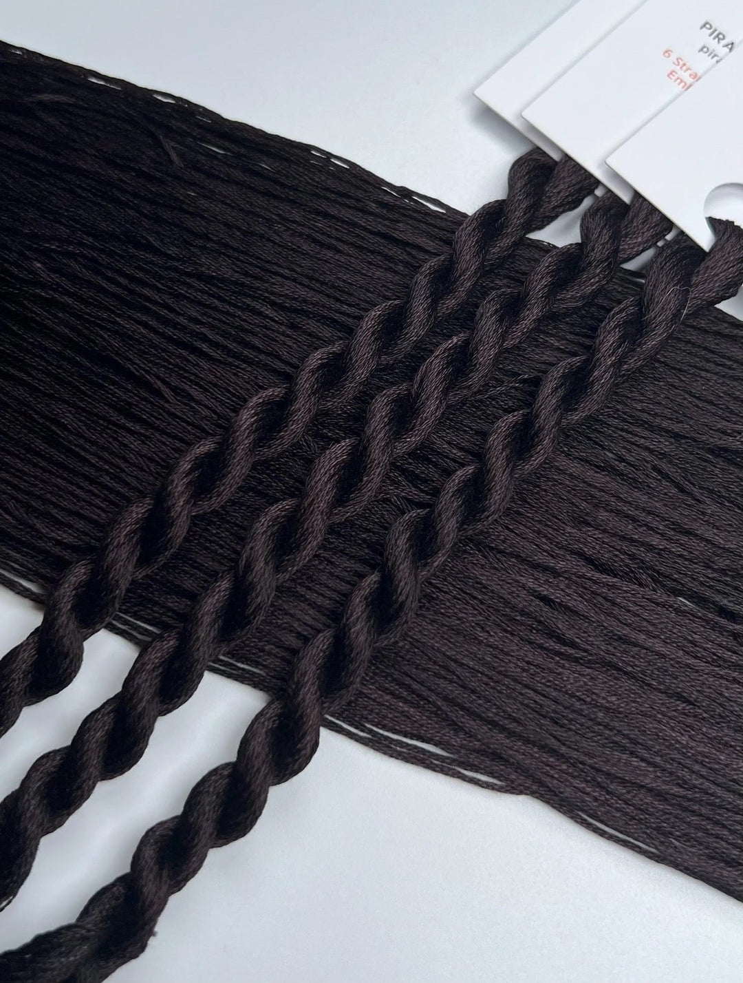dark Brown black thread skeins  on a white background