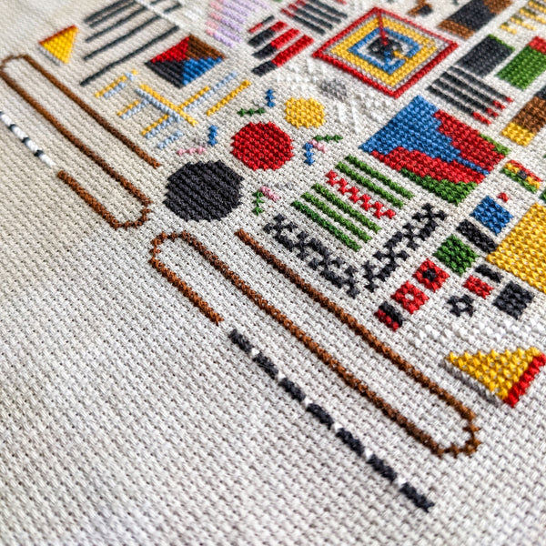 Cross-stitched design on fabric with colorful geometric patterns