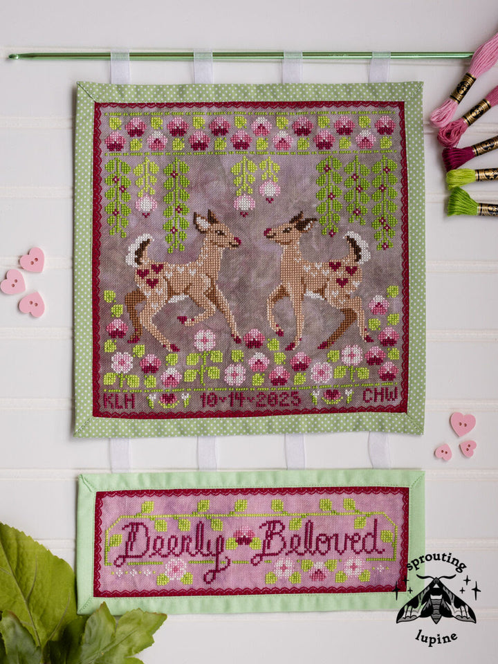 Cross-stitched deer design with floral elements on a white background, featuring the brand 'Lupine'.
