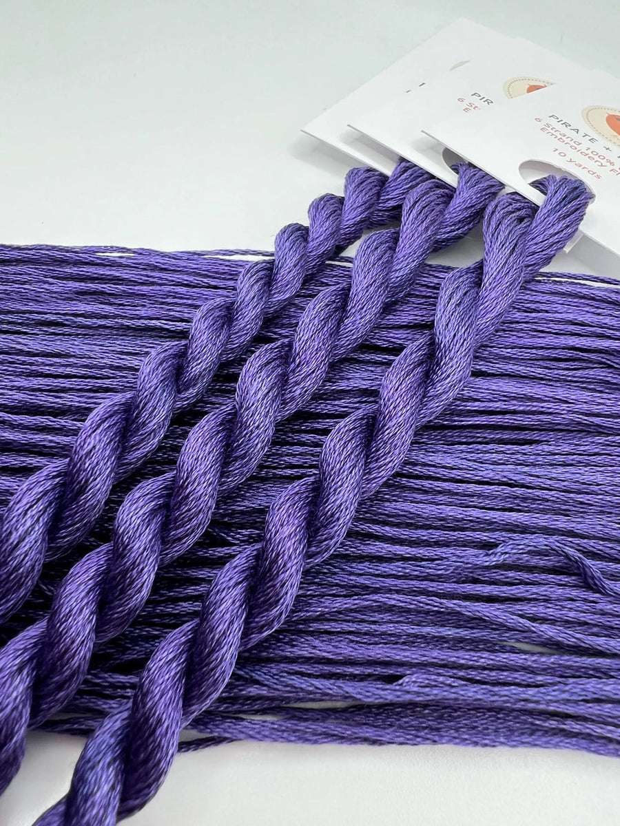 Purple yarn strands on a white background