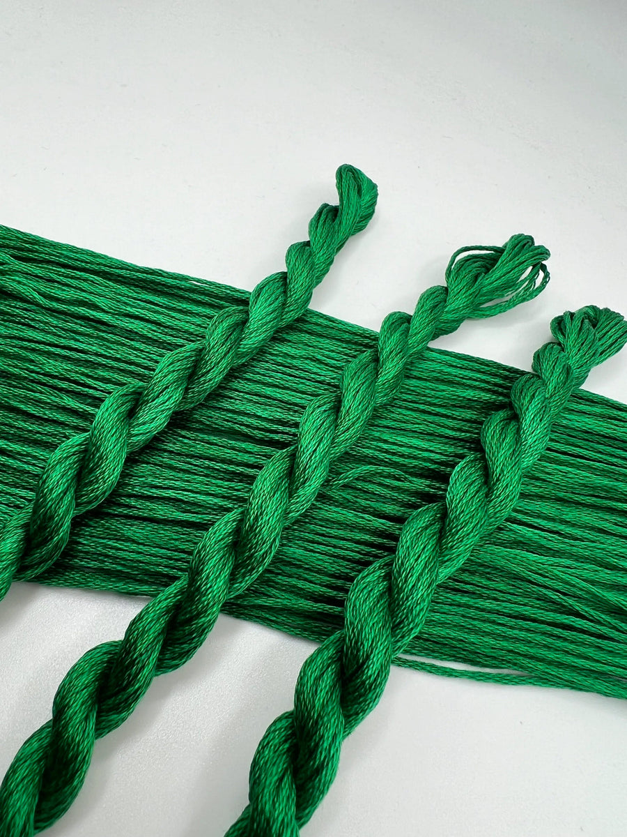 Green braided thread skiens  on a white background