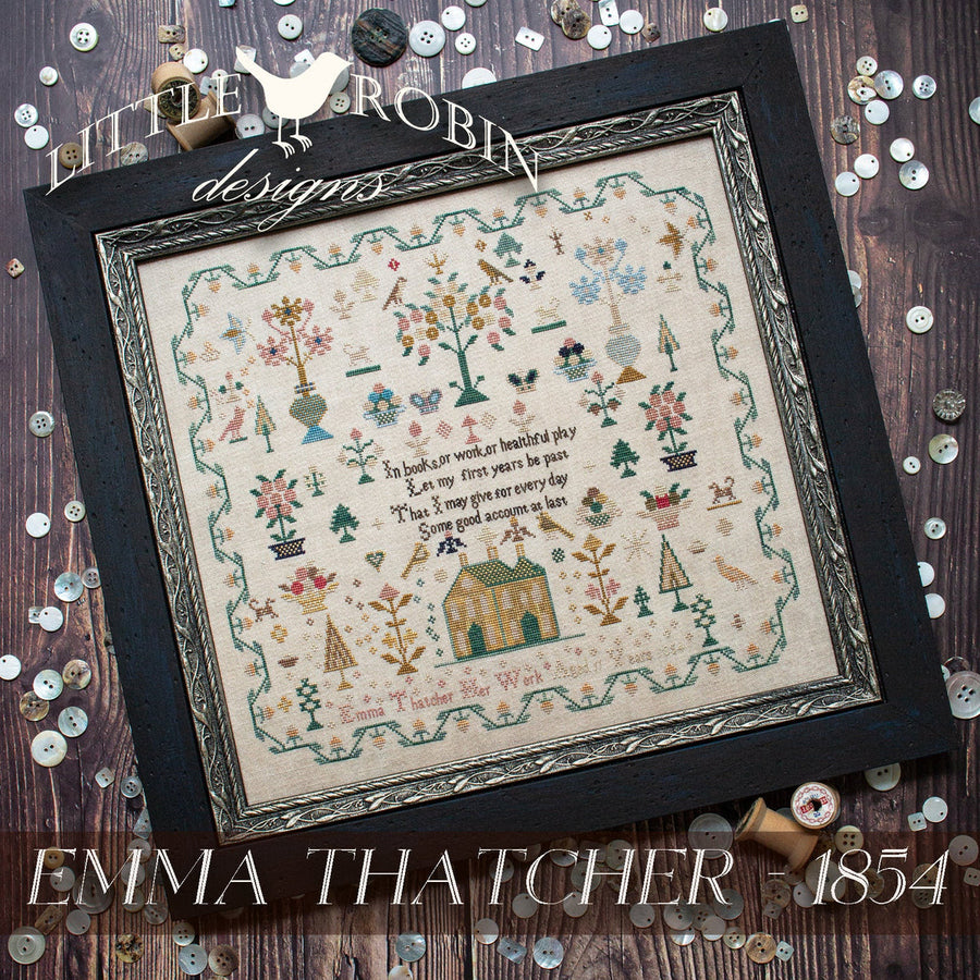 Framed cross-stitched piece with decorative elements on a wooden background