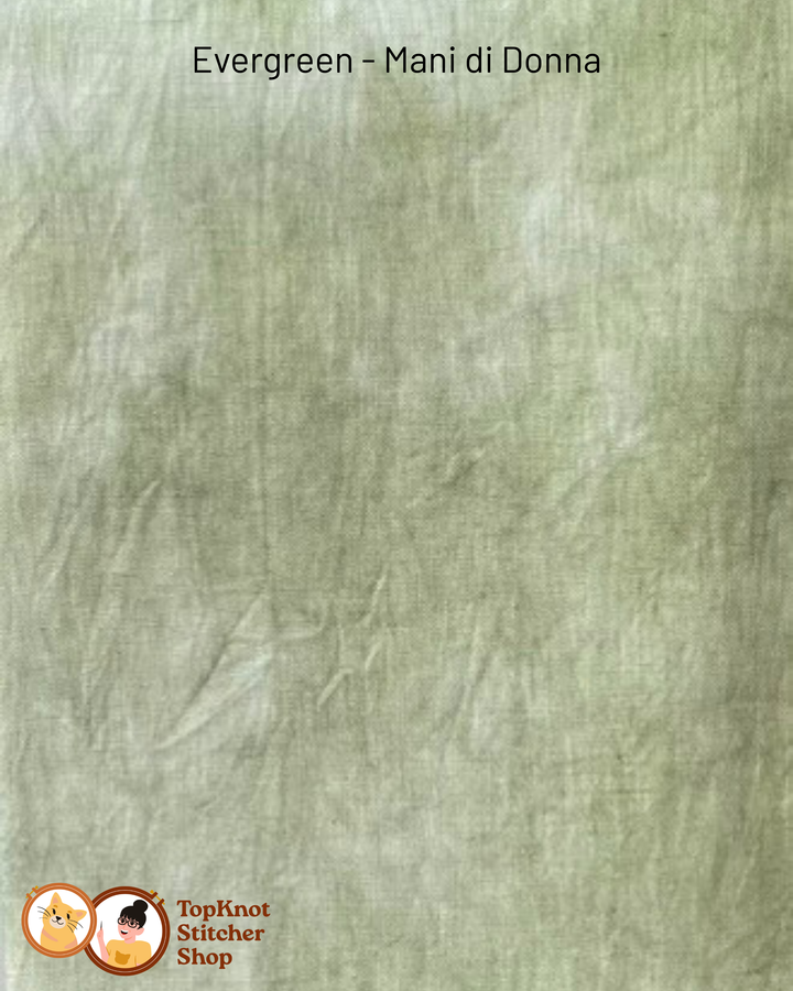 Textured light green fabric swatch with 'Evergreen - Mani di Donna' label and TopKnot Stitcher Shop logo.
