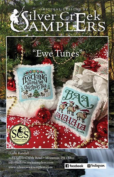 Cover of a Silver Creek Samplers needlework pattern titled "Ewe Tunes," showing two finished embroidered pillow designs placed on a red holiday blanket with ornaments and a gift box, framed by the brand logo and contact information.