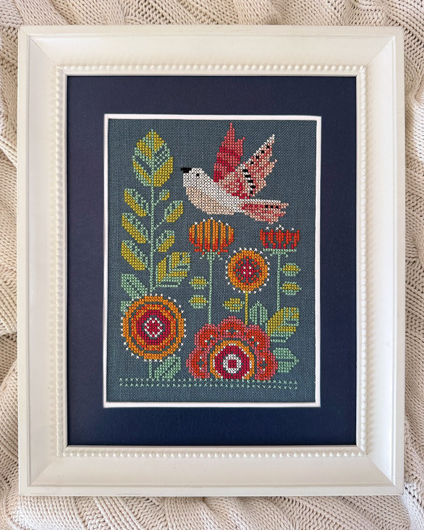 Cross-stitched design of a bird and flowers with 'Robin Pickens Cross Stitch' branding.
