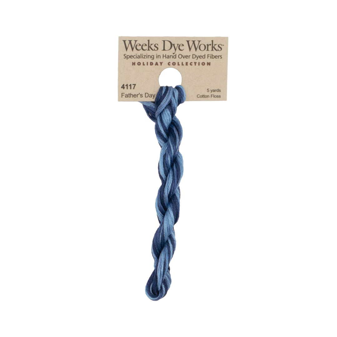 A single twisted hank of Weeks Dye Works 'Father's Day' cotton flax yarn in a dusty medium blue shade, attached to its original kraft paper packaging card against a solid white background.