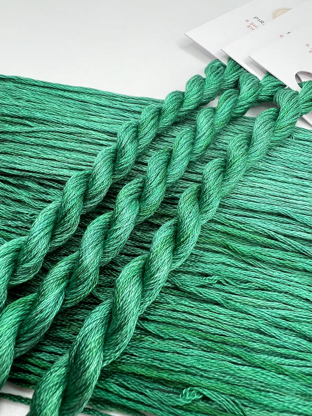 Close-up of green embroidery floss on a white background