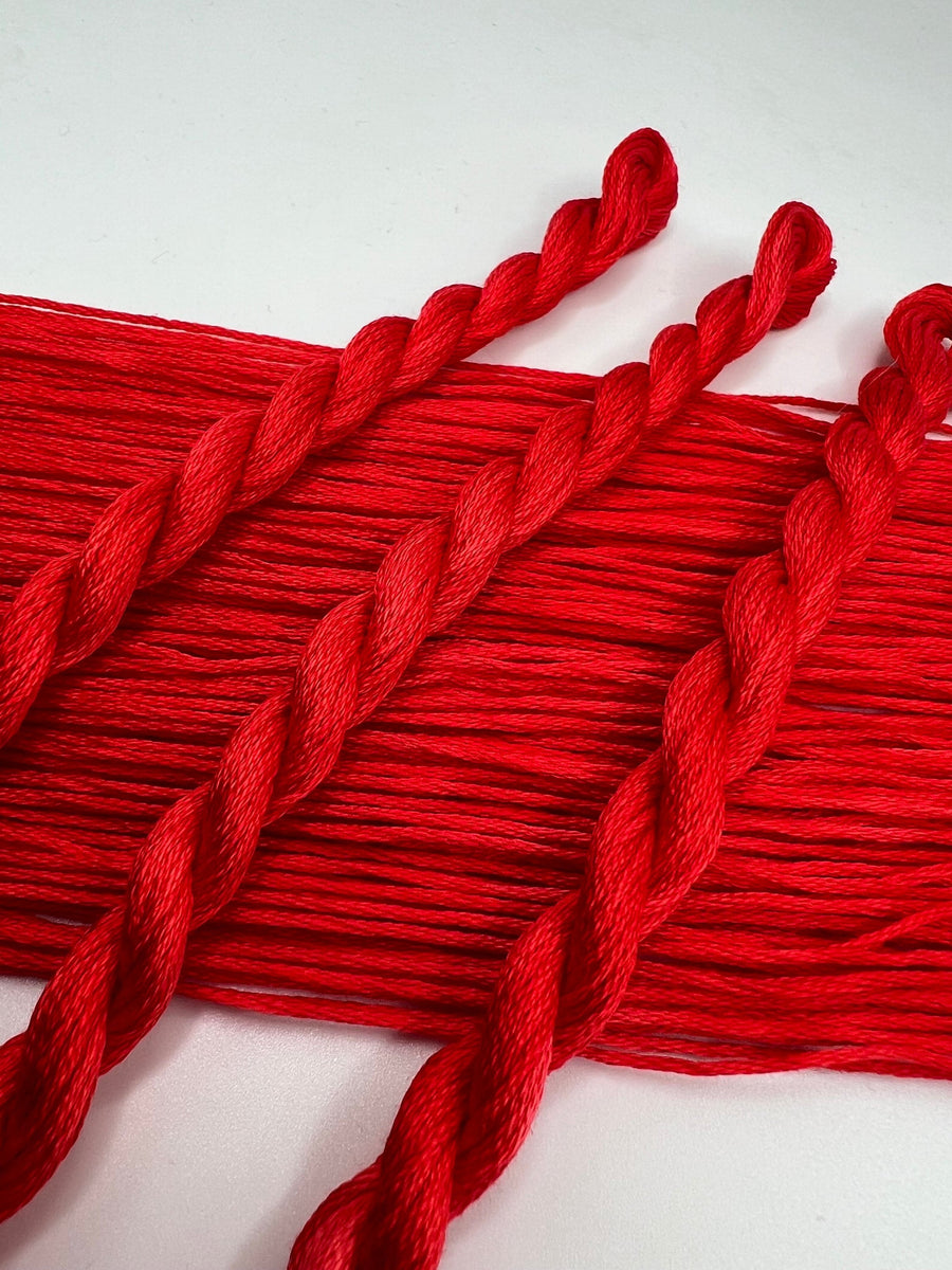 Red floss skeins on a white background