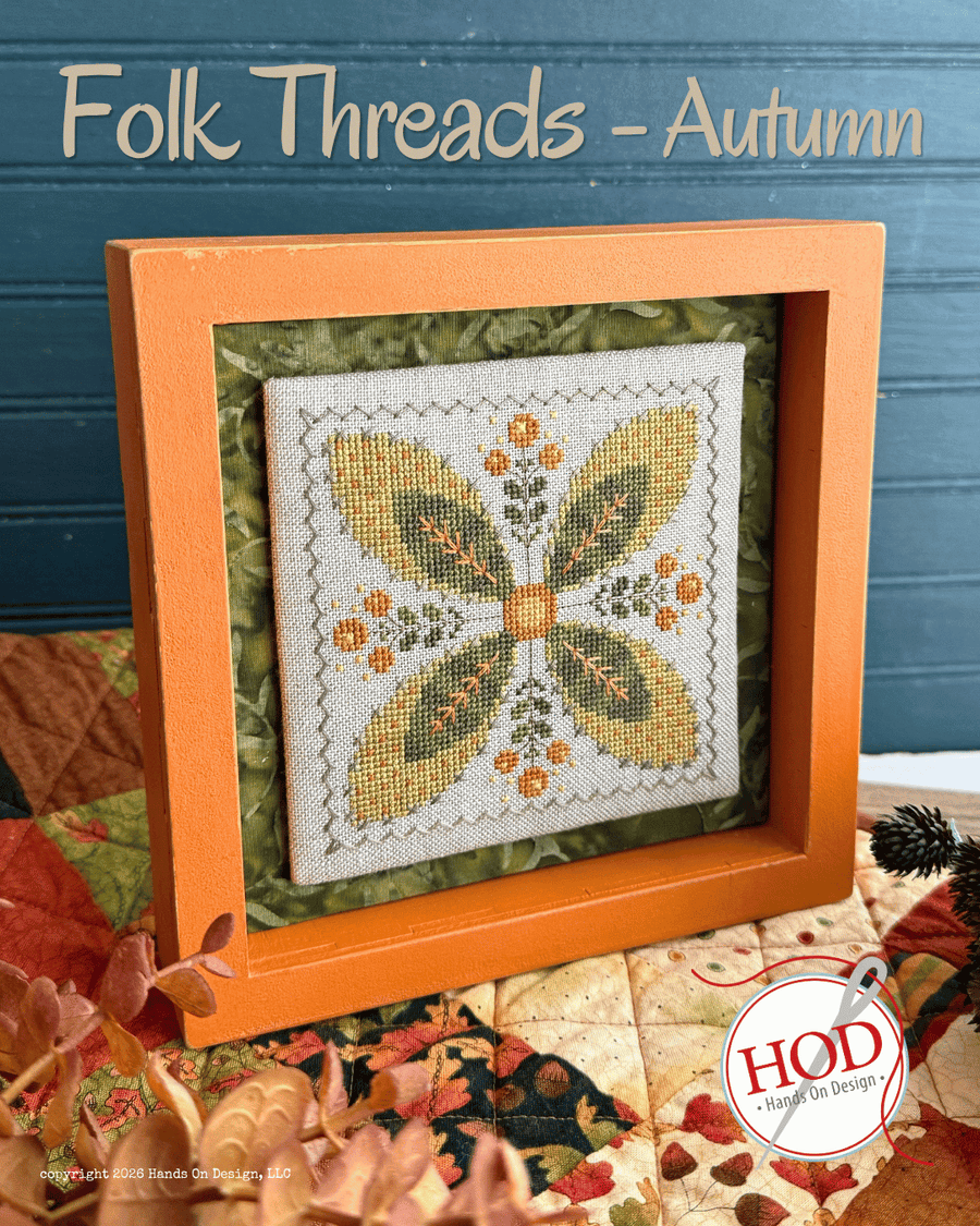 A framed autumn-themed needlepoint canvas titled 'Folk Threads - Autumn' displayed in an orange wooden frame. The needlepoint design features a butterfly motif in olive green, mustard yellow, and orange on a cream canvas.