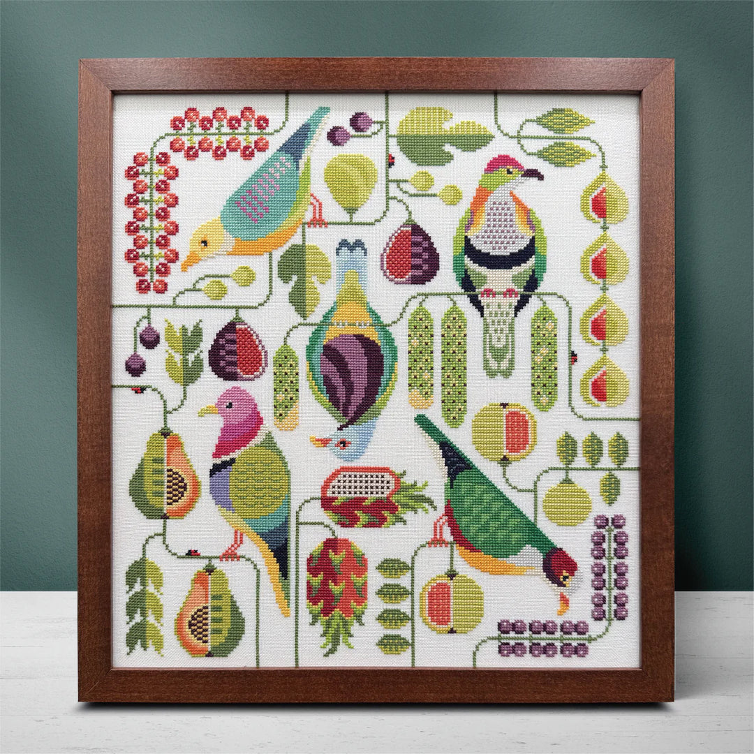 Framed cross-stitch pattern with colorful birds and foliage on a white background