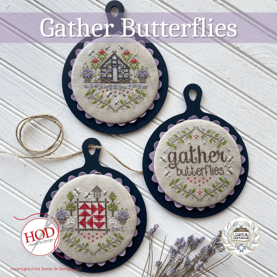Three embroidered round ornaments with 'gather butterflies' text on a textured white surface.