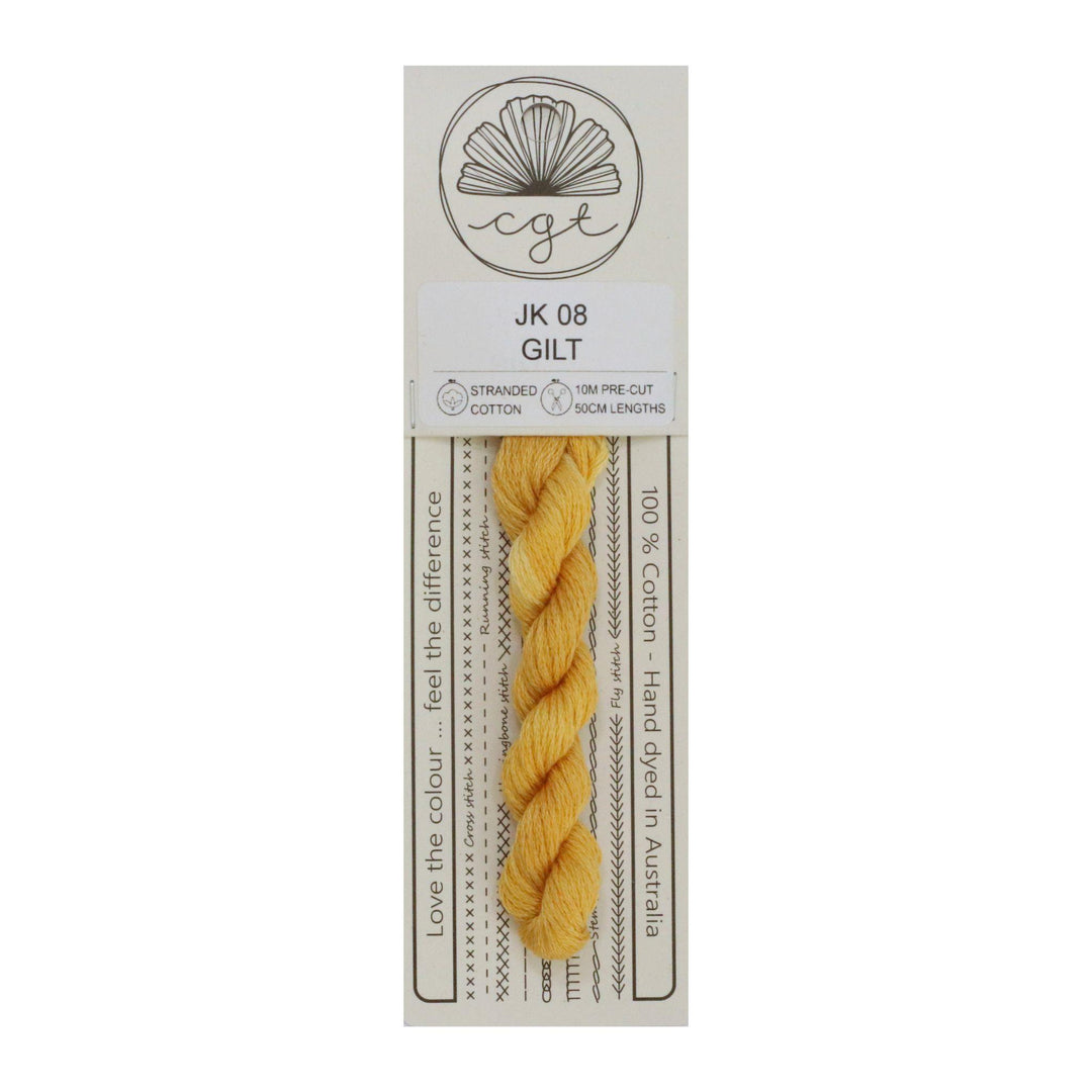 A skein of hand-dyed yellow embroidery floss labeled 'Gilt' from Cottage Garden Threads, with eco-friendly packaging.