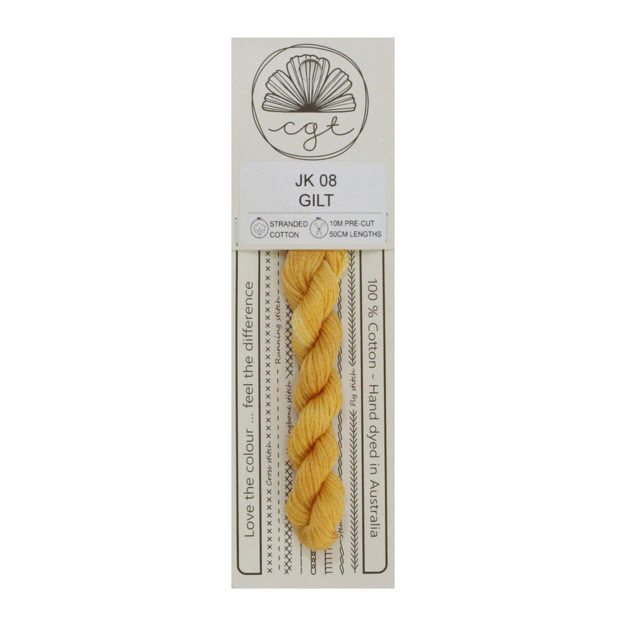 A skein of hand-dyed yellow embroidery floss labeled 'Gilt' from Cottage Garden Threads, with eco-friendly packaging.
