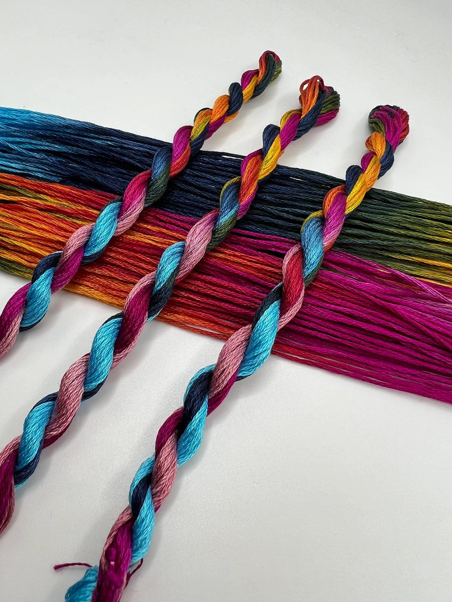 Colorful thread skeins of pride and trans flag colors on a white background