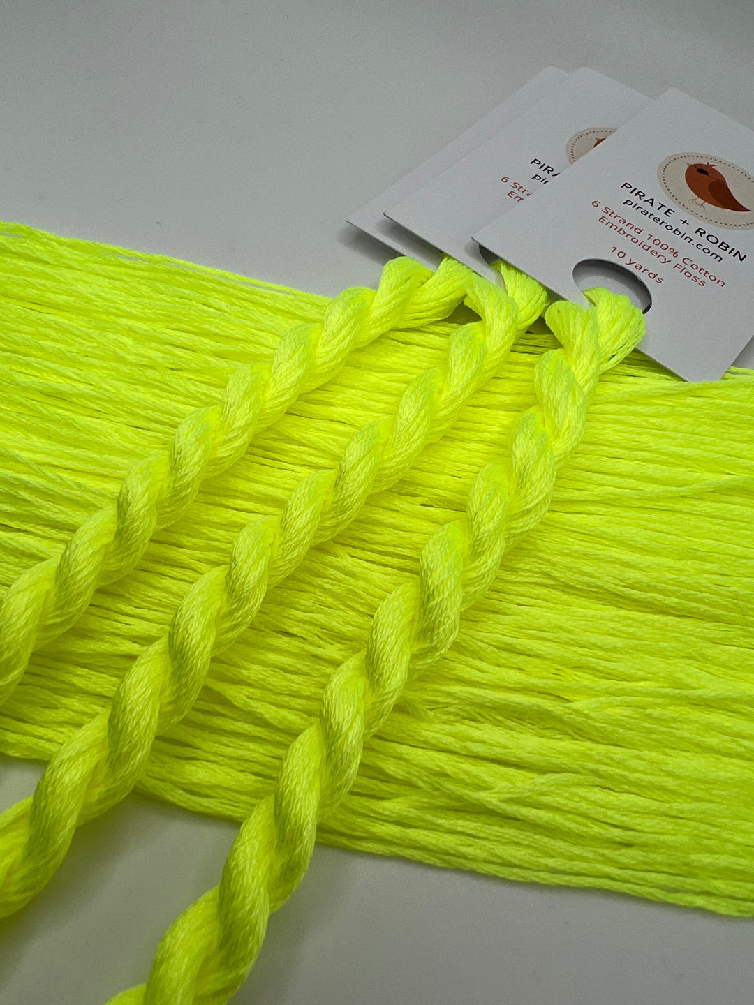 Neon yellow yarn with a label on a light gray background