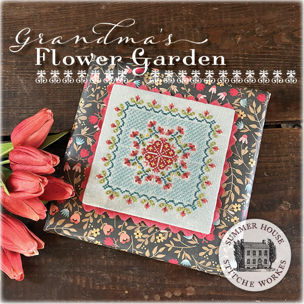 Embroidery kit with floral design on a wooden surface with pink tulips