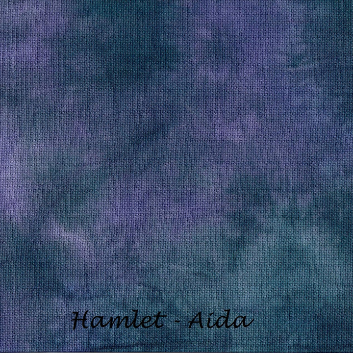 A close-up of a textured fabric or wallpaper swatch in a mottled blend of deep purple and dark teal-blue, with the text 'Hamlet - Aida' written in black script at the bottom.