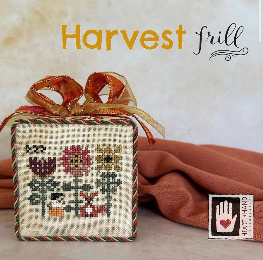 Cross-stitched box with autumn-themed design and 'Harvest Frill' text on a neutral background