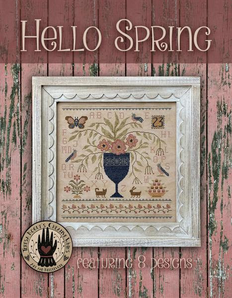 Framed cross-stitch pattern with floral design on a rustic wooden background, featuring the brand 'Mercy Street Studio'.