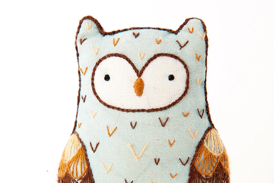Owl-shaped plush toy with a light blue background