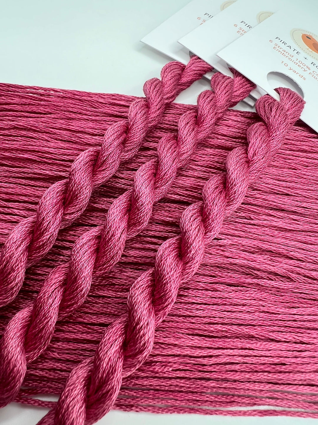 Pink embroidery floss with packaging on a white background