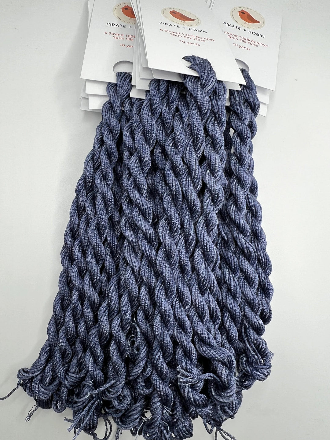 Bundles of blue thread skeins with tags on a white background