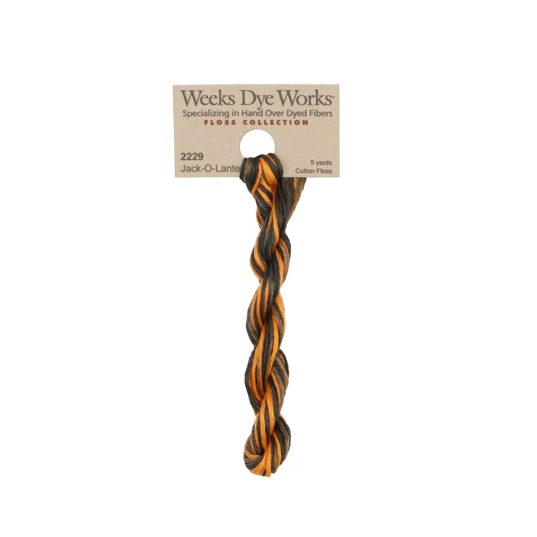 A twisted cotton fiber dog toy in black and orange, attached to a kraft paper header card from Weeks Dye Works, shown against a plain white background.