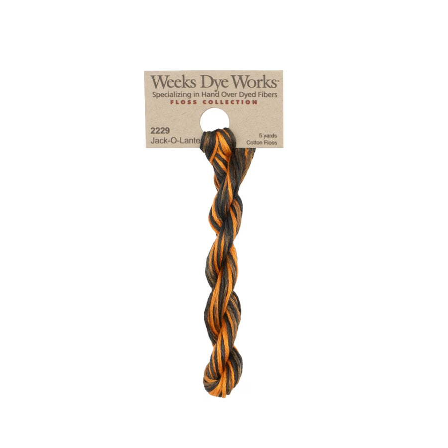 A twisted cotton fiber dog toy in black and orange, attached to a kraft paper header card from Weeks Dye Works, shown against a plain white background.