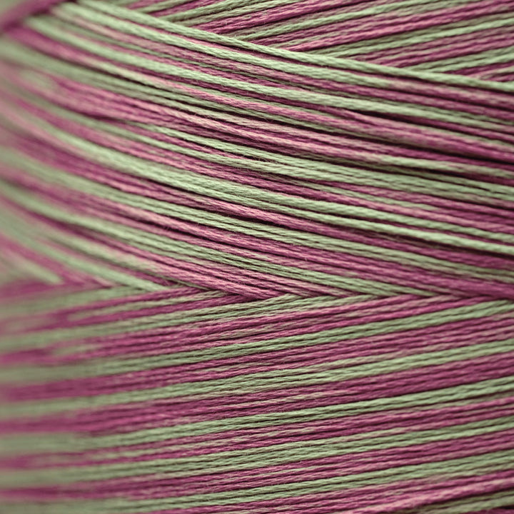 Close-up of variegated yarn with alternating stripes of dusty pink and sage green.