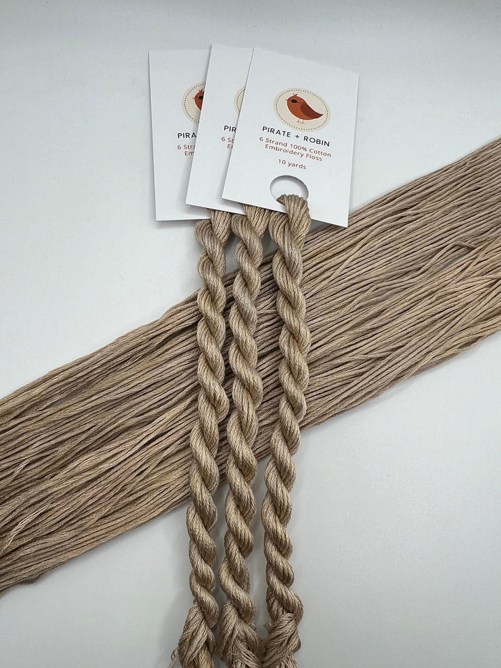 Two braided skeins with tags on a light gray background