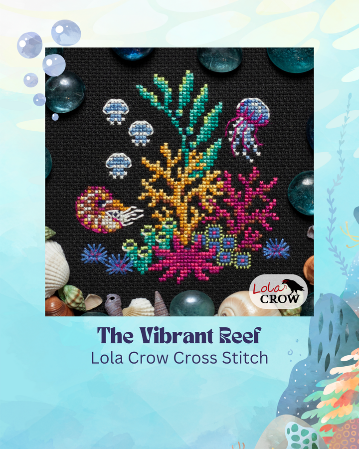 Cross stitch pattern of a vibrant reef with fish, coral, and jellyfish on a black background.