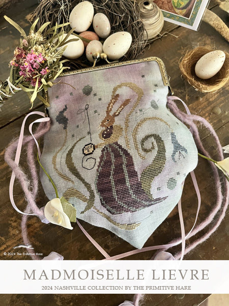 Decorative bag with embroidered design on a wooden surface with eggs and flowers, featuring 'Mademoiselle Lievre'