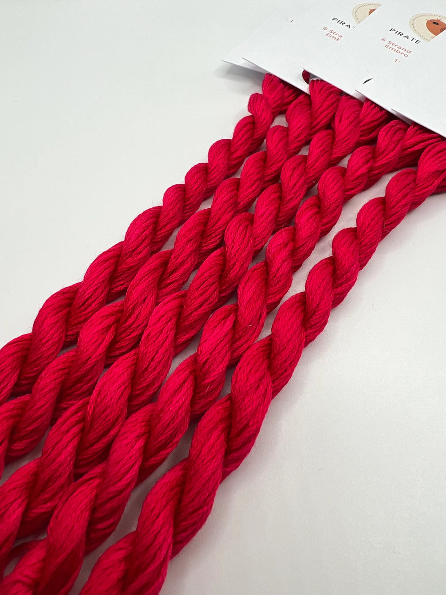 Red thread skeins on a white background
