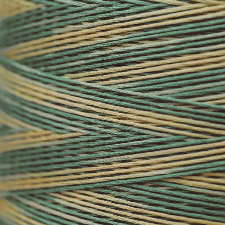 Close-up of variegated thread wound in a cone, showing alternating stripes of sage green, olive green, and tan.