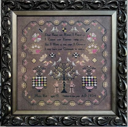 Decorative cross-stitched sampler with intricate patterns and text, framed in an ornate black frame.