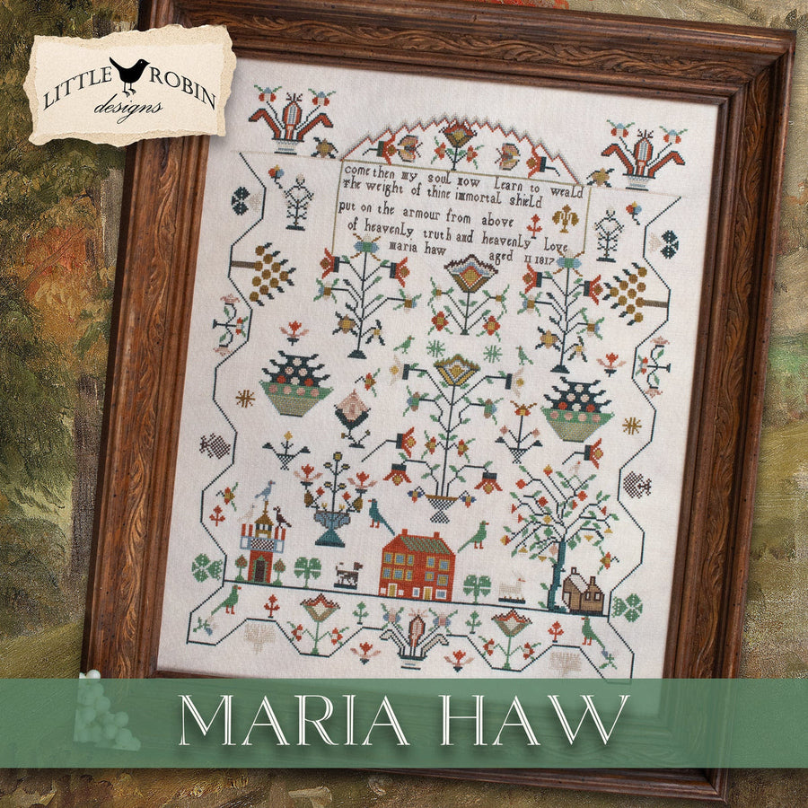 A framed cross-stitch sampler titled 'Maria Haw' by Little Robin Designs, featuring a detailed folk-art design with a house, trees, flowers, and a poem on cream fabric, enclosed in a dark wood frame.