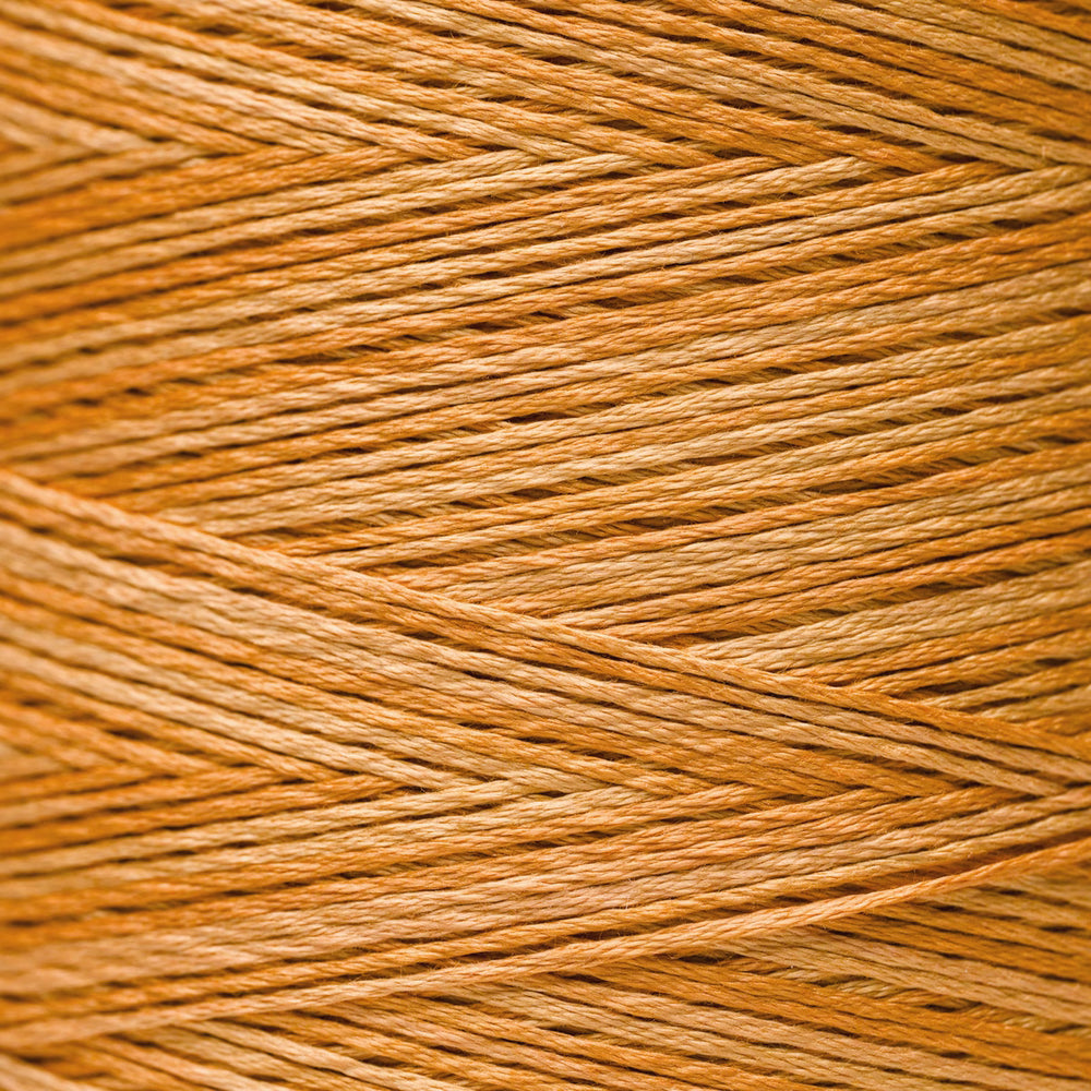 A close-up texture shot of warm golden-brown thread or yarn strands wound diagonally across the frame.