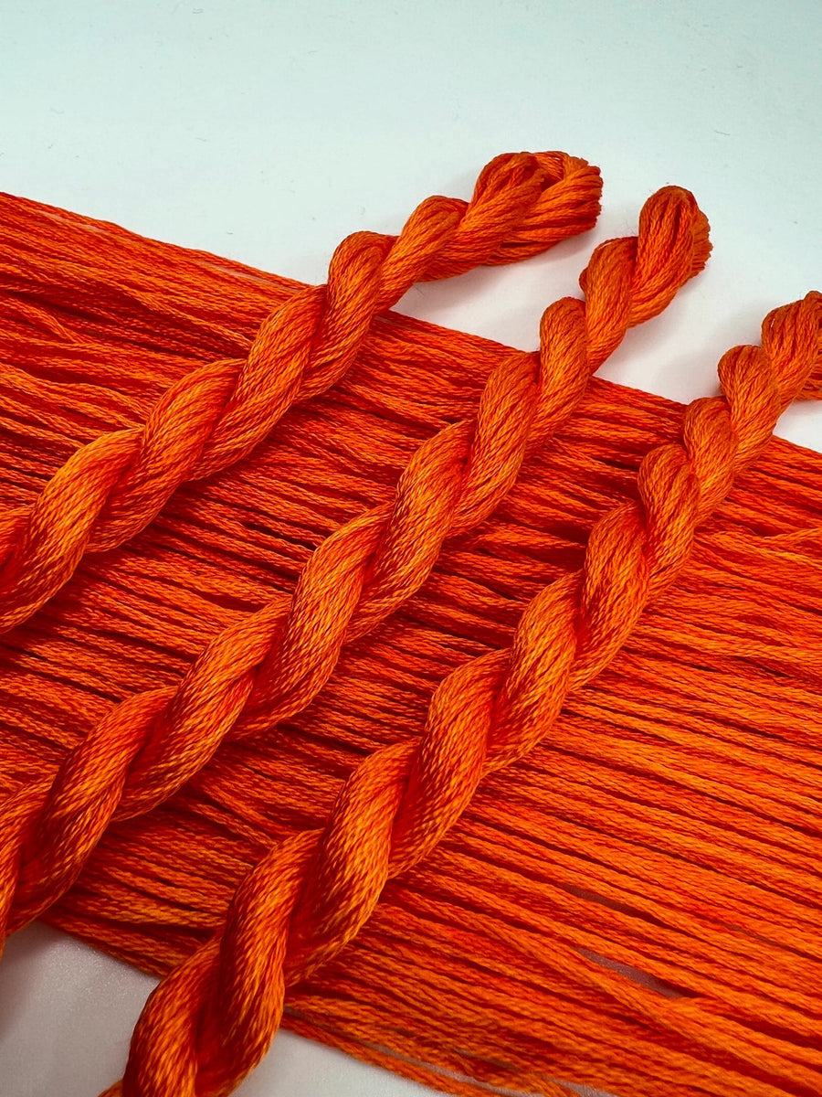 Close-up of orange embroidery floss on a white background