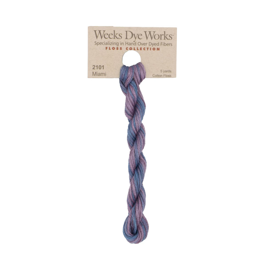 A single twisted bundle of Weeks Dye Works Miami cotton embroidery thread in a variegated purple and blue shade, attached to a brown paper header card.