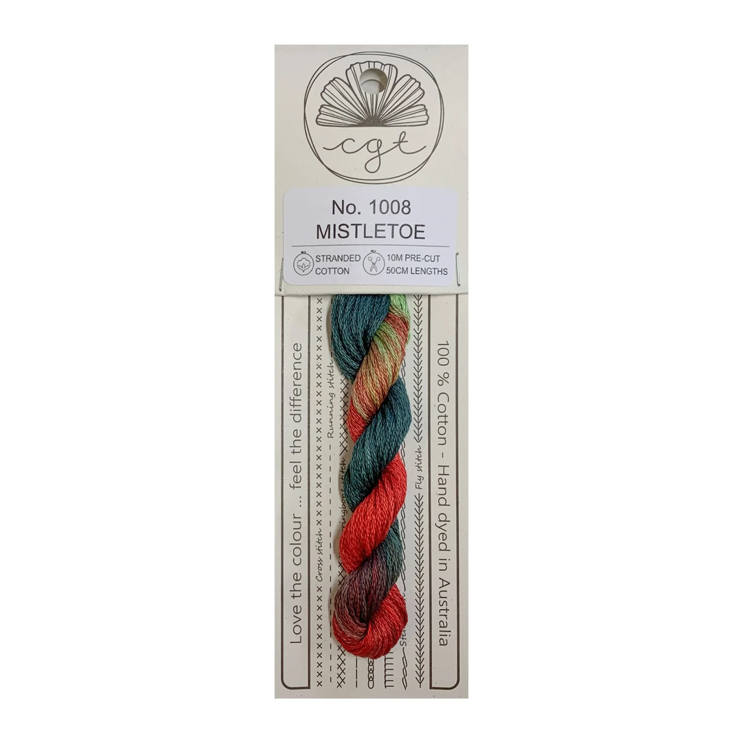 A skein of hand-dyed cotton cross stitch and embroidery floss in red, green, and blue colors, labeled 'Mistletoe' from Cottage Garden Threads.