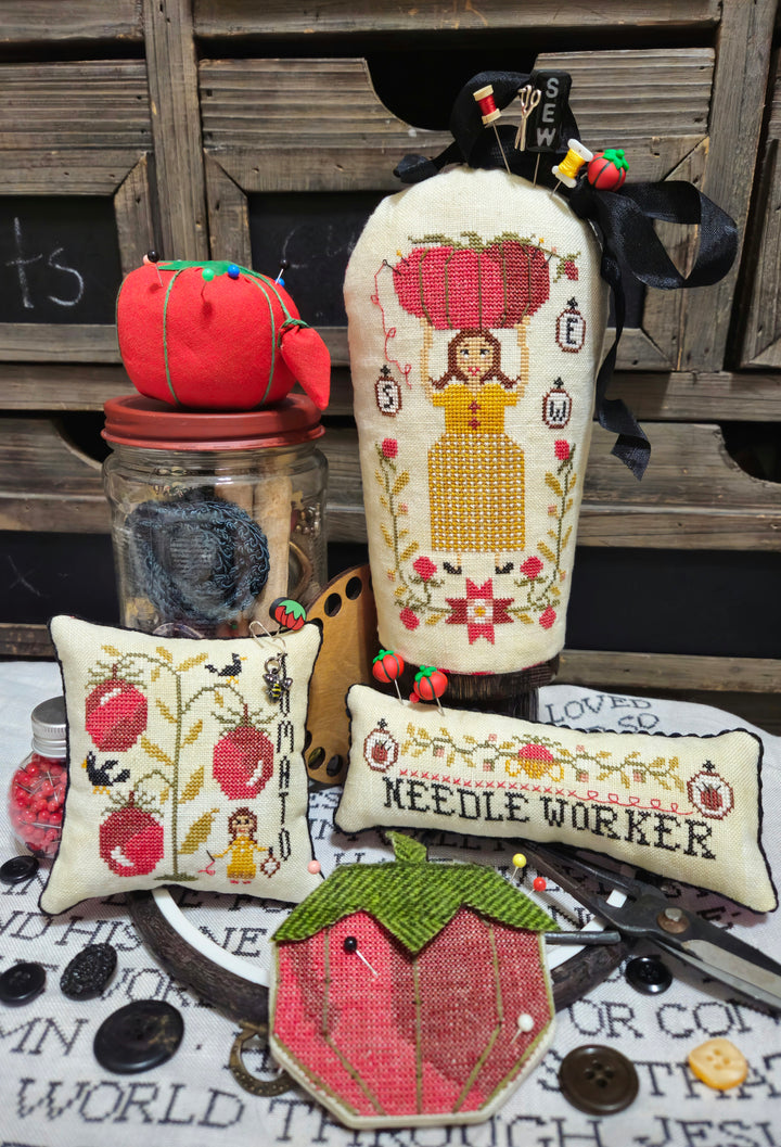 Decorative items including a bottle with cross-stitch design, small pillows, and a jar on a wooden surface.