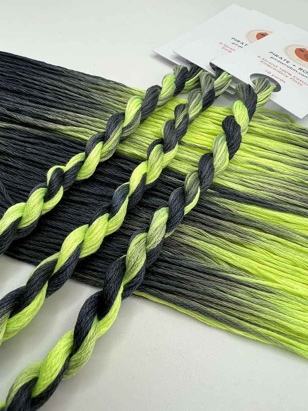 Black and green twisted thread skeins with a white background