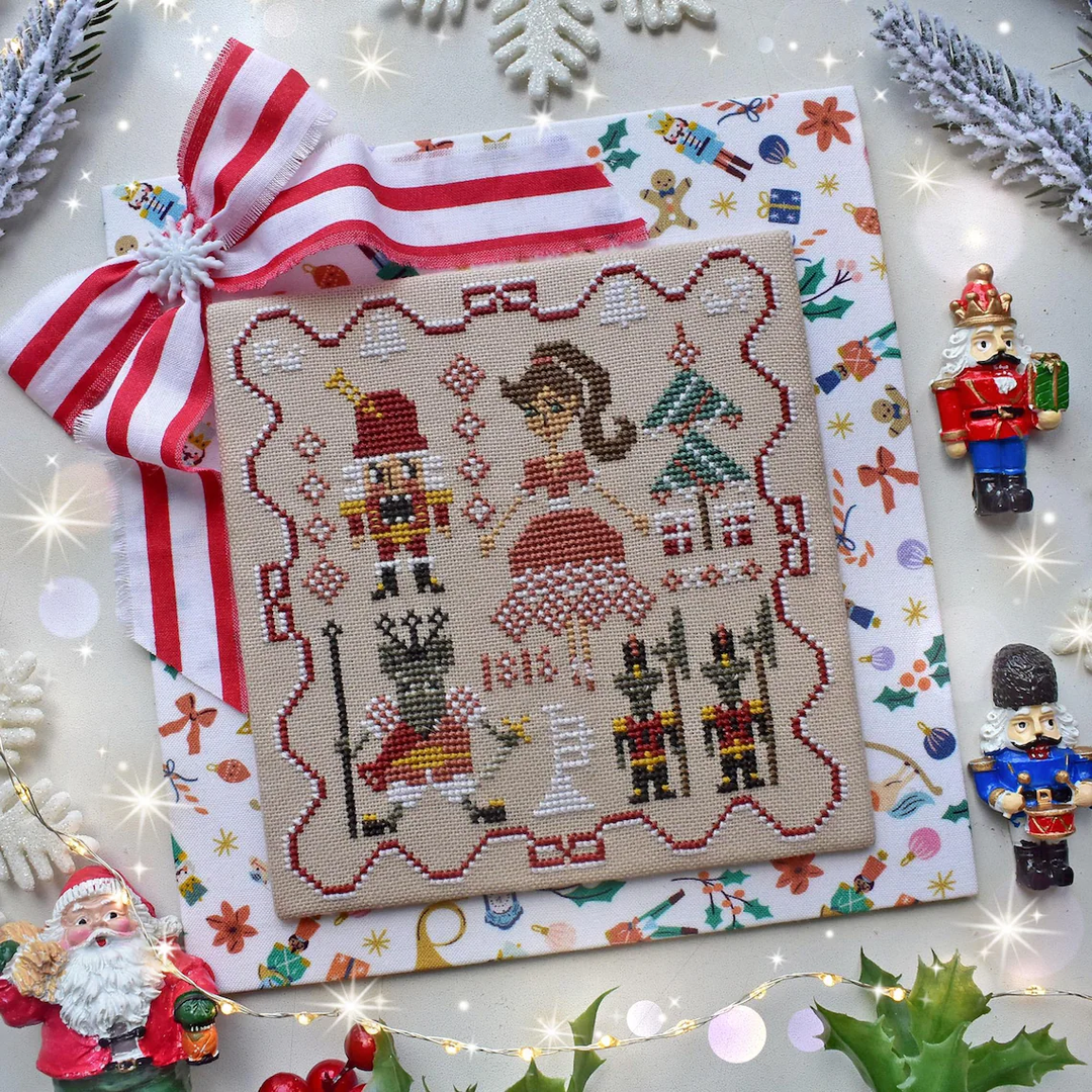 Cross-stitched design with Christmas-themed characters on a decorative background with ornaments.