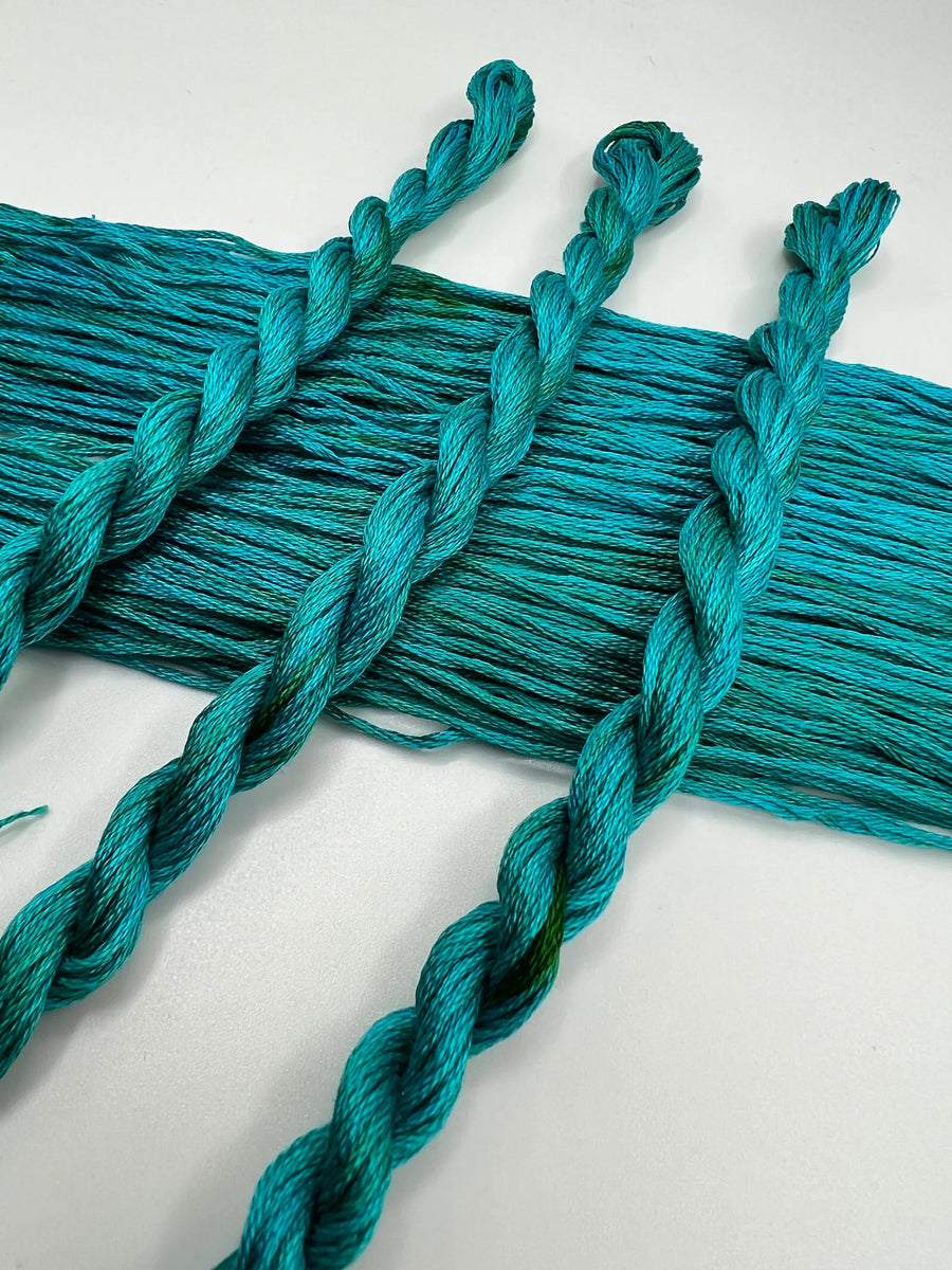 Turquoise yarn with braided ends on a white background