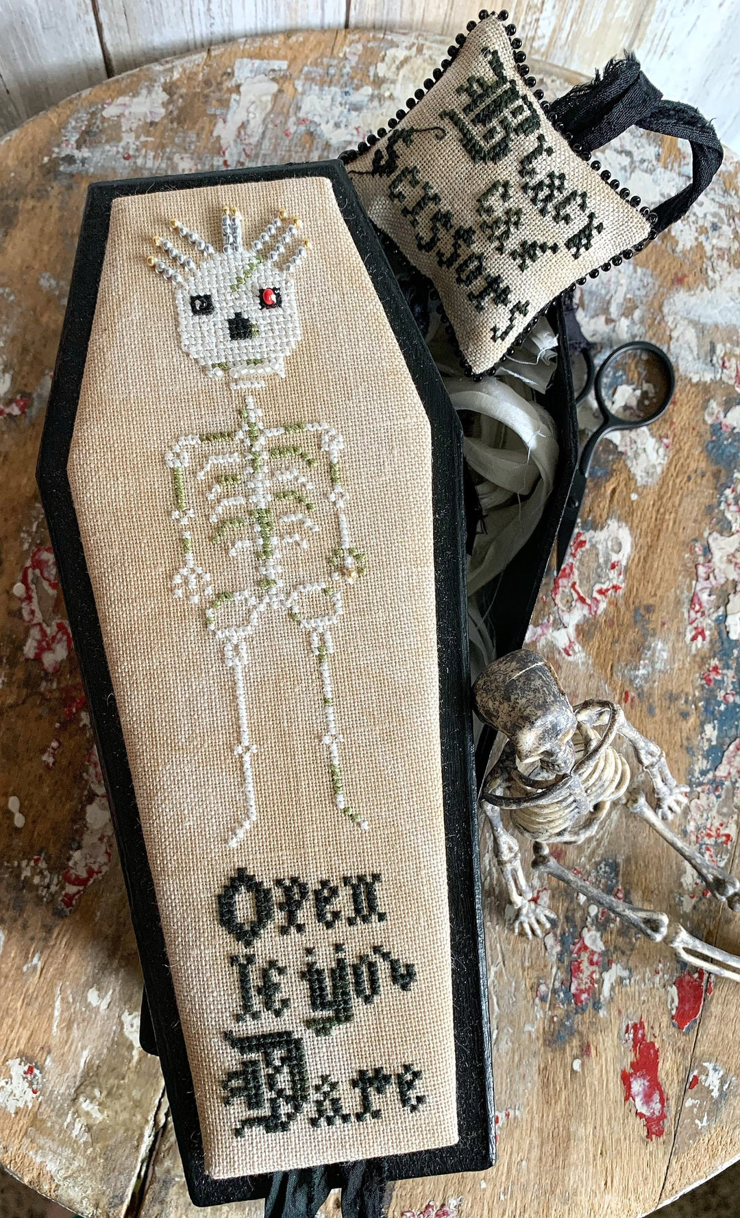 Decorative coffin with skeleton design and text on a textured surface