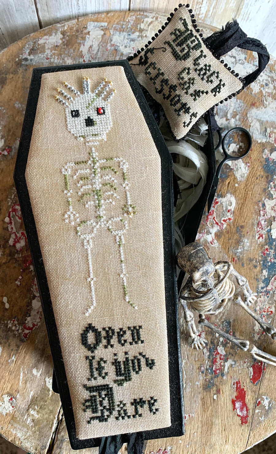 Decorative coffin with skeleton design and text on a textured surface
