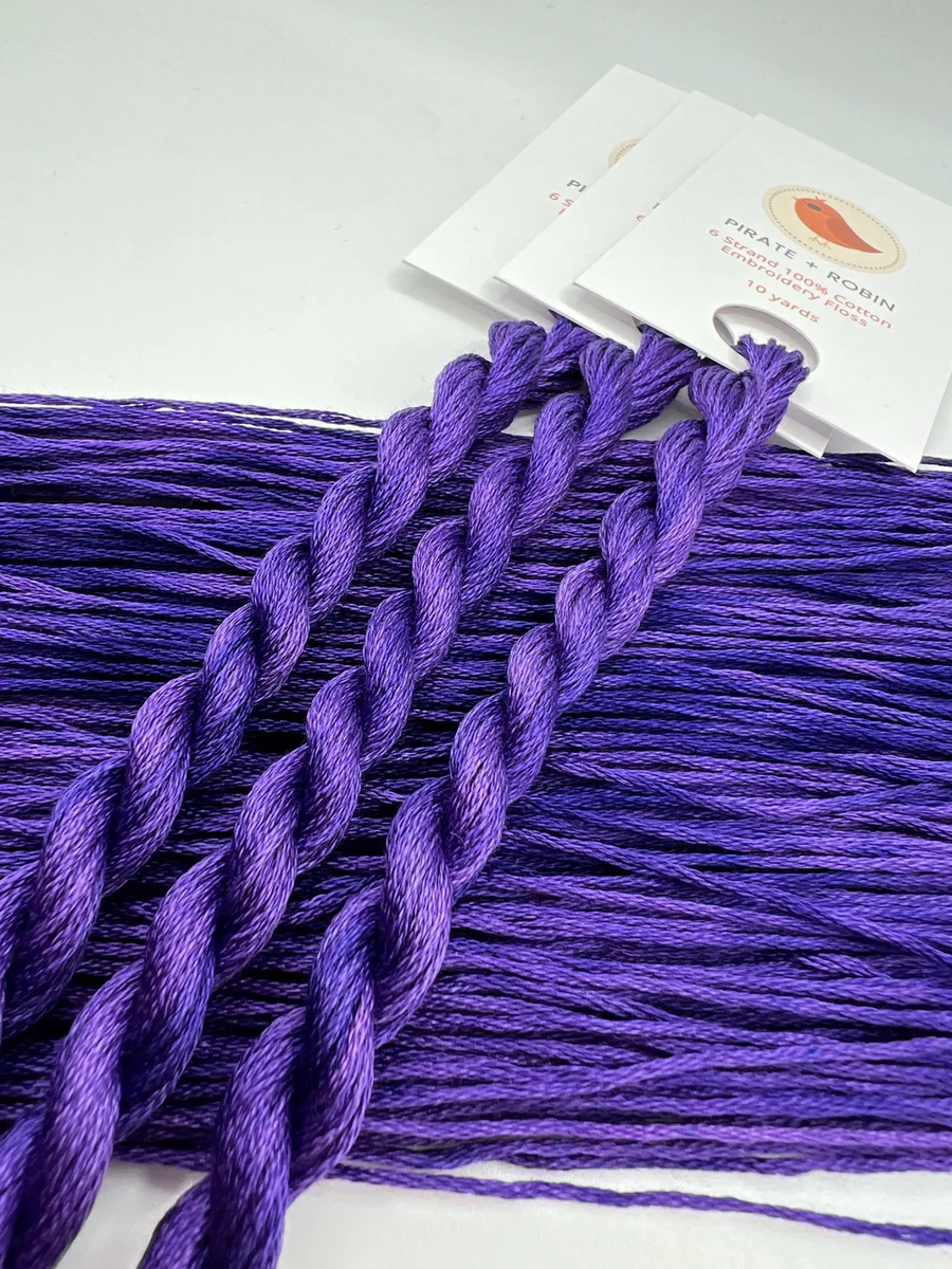 Purple braided embroidery floss  with a brand card in the background