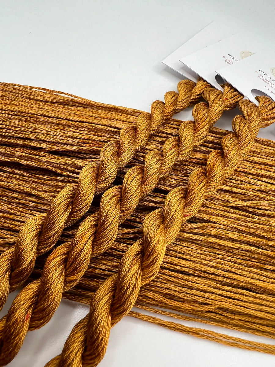 Mustard yellow yarn strands on a white background