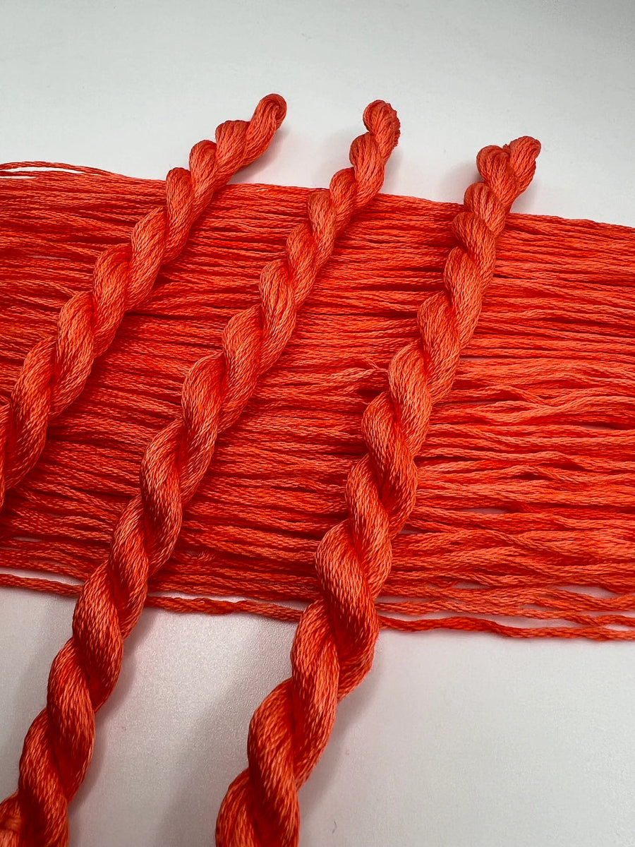 Close-up of red embroidery floss on a white background