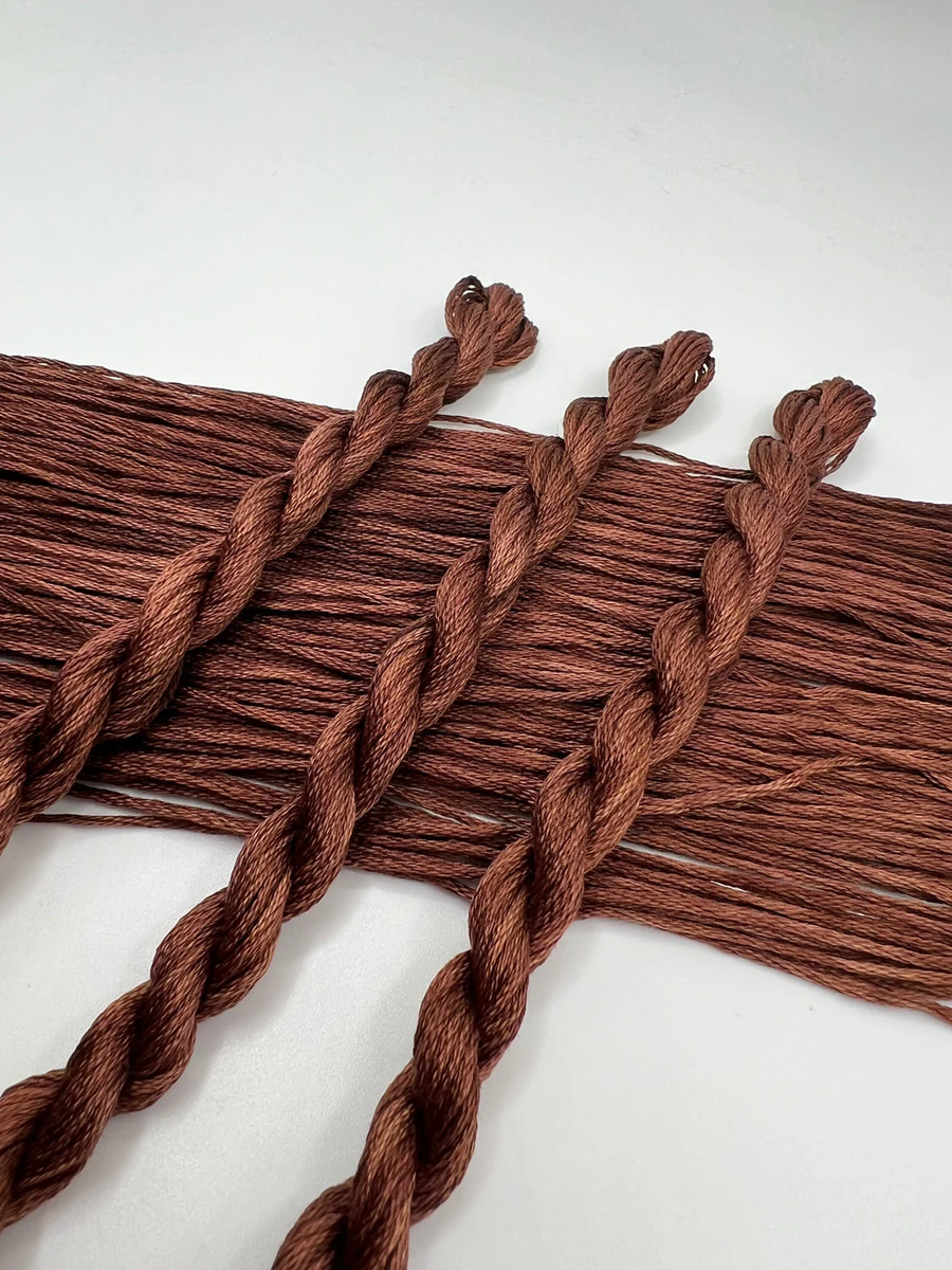 Close-up of brown braided yarn on a white background